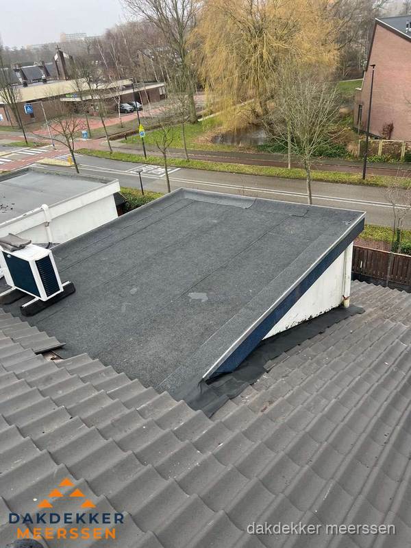 Plat dak met bitumen dakbedekking naast schuin pannendak in Meerssen