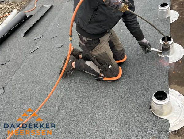 Dakdekker repareert bitumen dakleer bij dakdoorvoer in Meerssen Dakdekker repareert bitumen dakleer bij dakdoorvoer in Meerssen