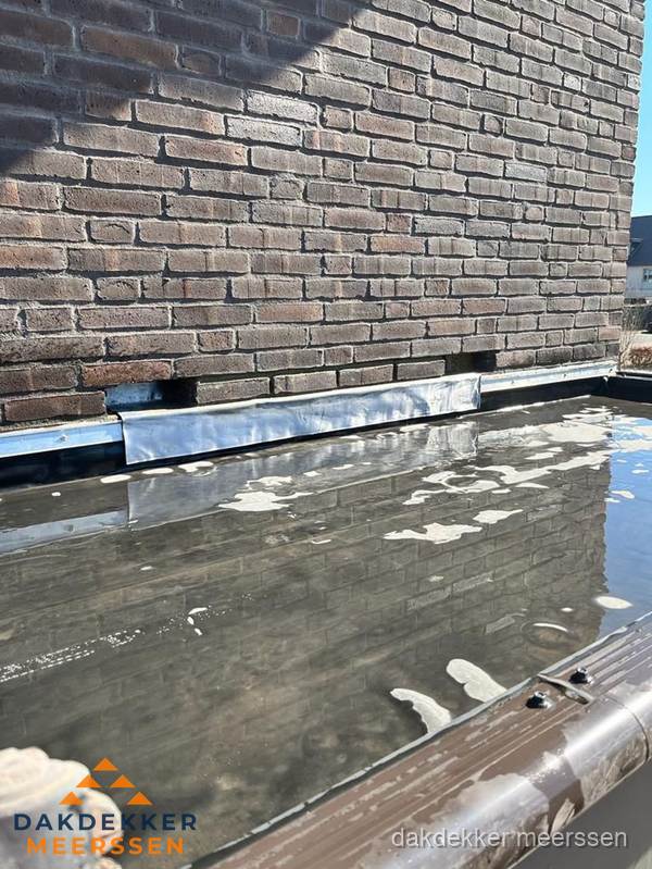 Stilstaand water op plat dak door slechte afwatering in Meerssen Stilstaand water op plat dak door slechte afwatering in Meerssen