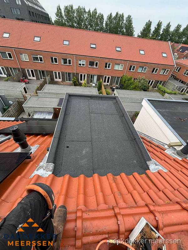 Bitumen dak reparatie op plat dak tussen dakpannen in Meerssen