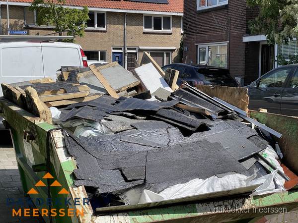 Afvalcontainer met gesloopt dakmateriaal tijdens dakkapel renovatie in Meerssen Afvalcontainer met gesloopt dakmateriaal tijdens dakkapel renovatie in Meerssen