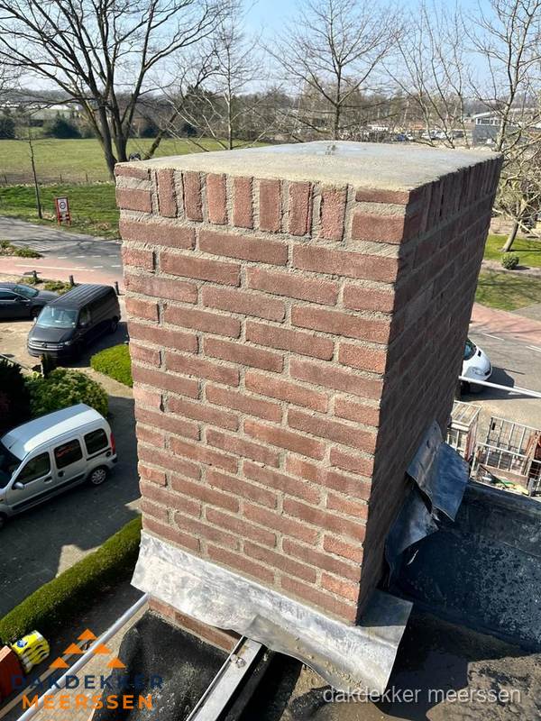 Gemetselde schoorsteen met loodaansluiting op dak in Meerssen Gemetselde schoorsteen met loodaansluiting op dak in Meerssen